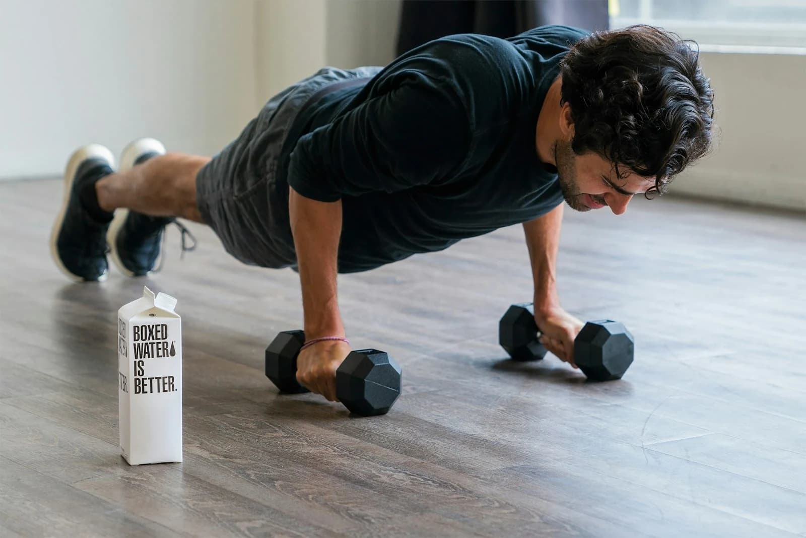 Gym member doing push-ups on hex dumbbells at a strength training gym